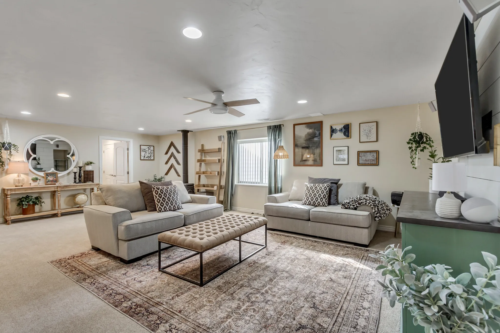 Living room featuring recessed lighting, carpet flooring, a wood stove, and ceiling fan