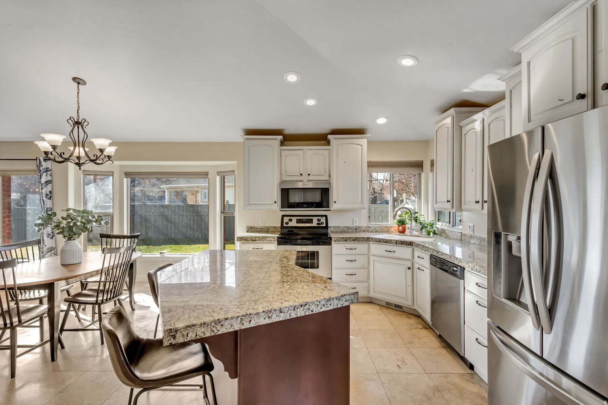 Kitchen with stainless steel appliances, pendant lighting, a center island, a kitchen breakfast bar, and recessed lighting