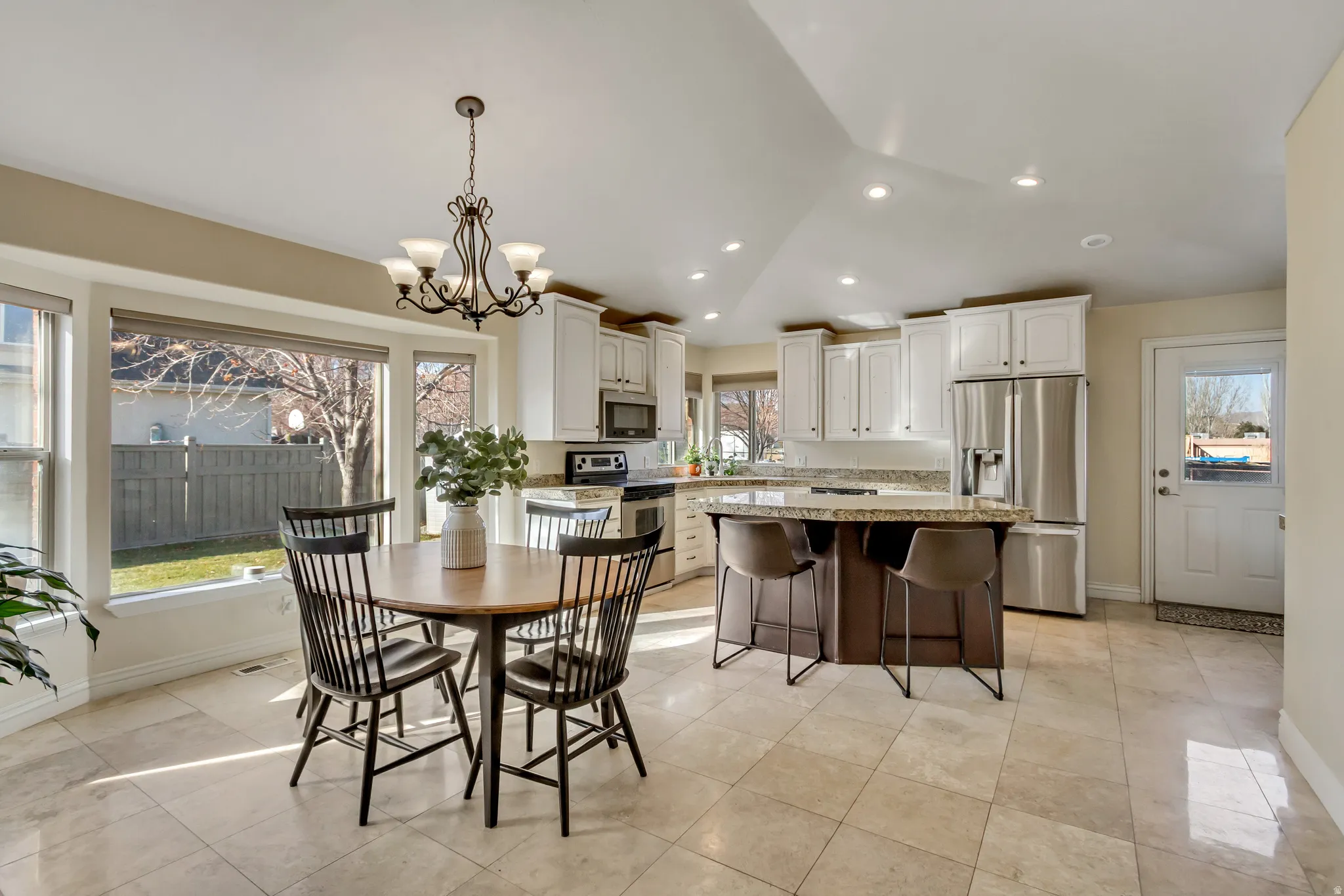 Dining room with a chandelier, lofted ceiling, and recessed lighting