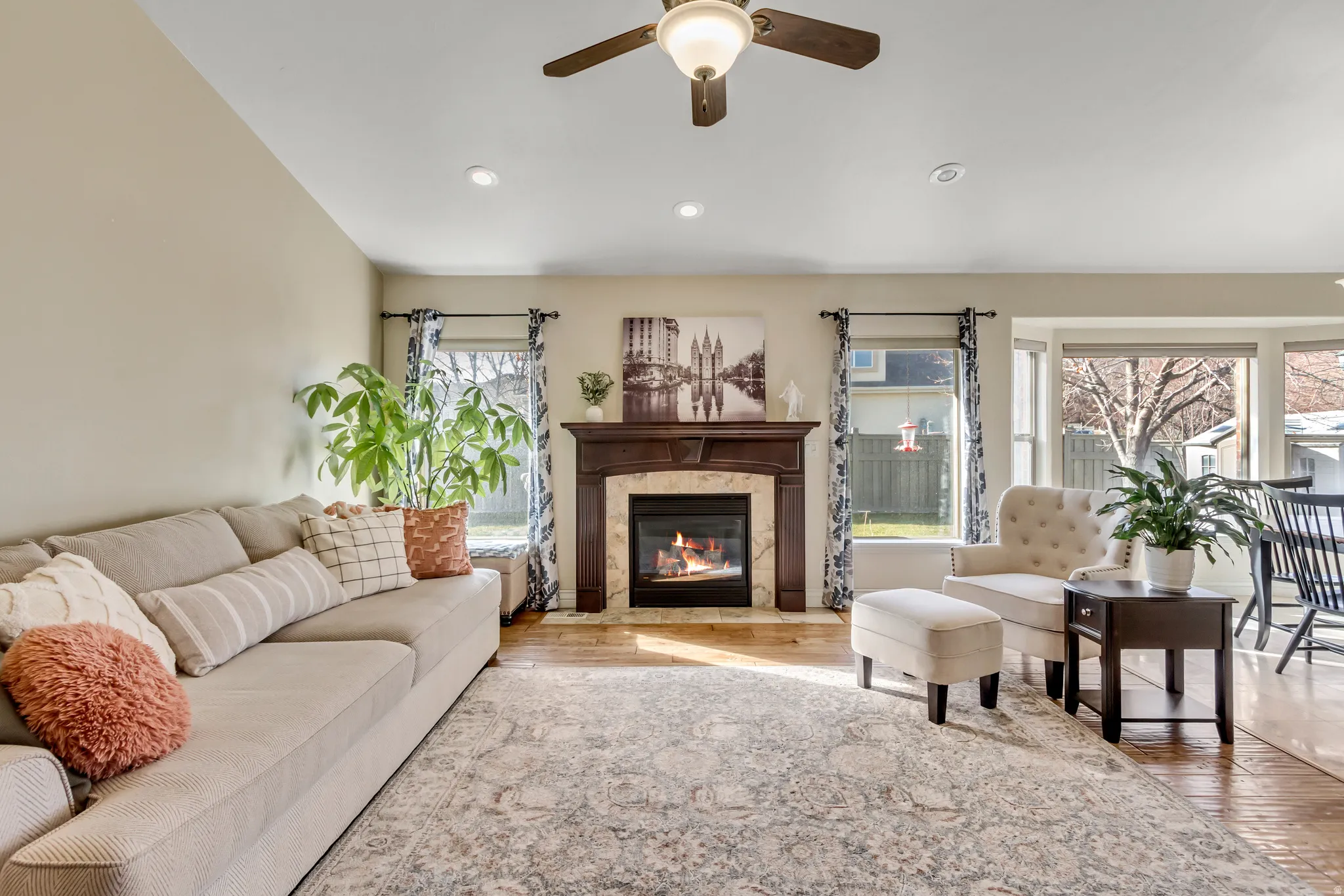 Living area with light wood finished floors, a high end fireplace, recessed lighting, and a ceiling fan