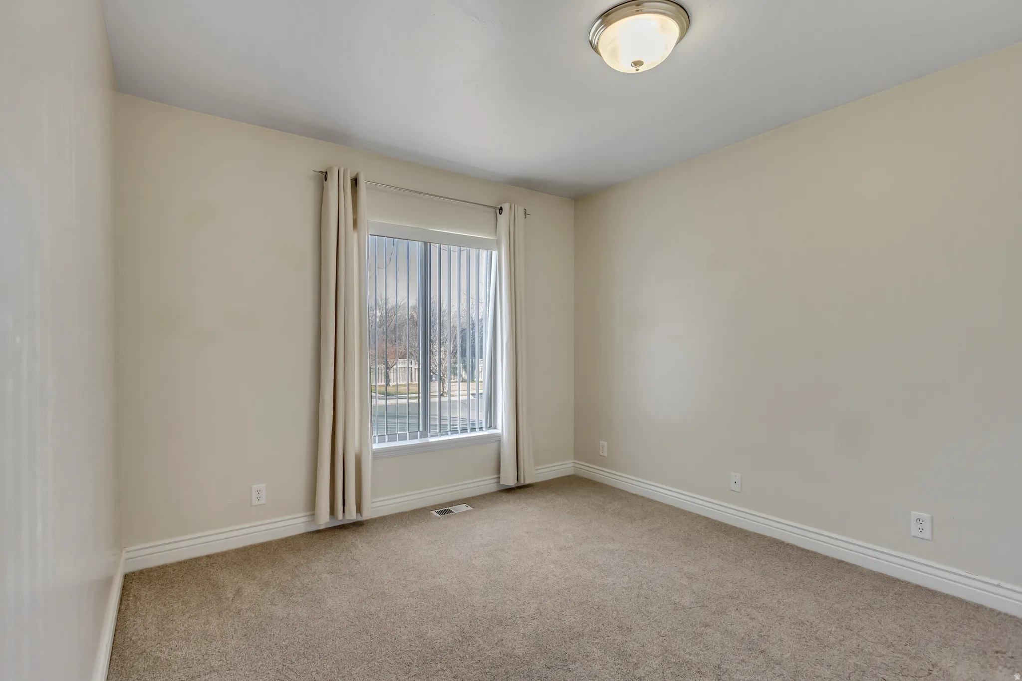 Empty room with light carpet and baseboards