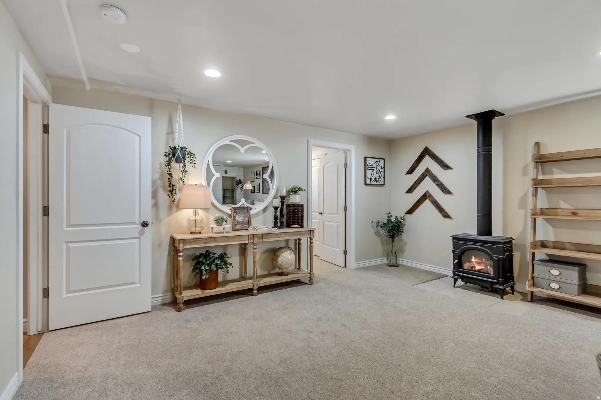 Living area featuring a wood stove, light carpet, and recessed lighting