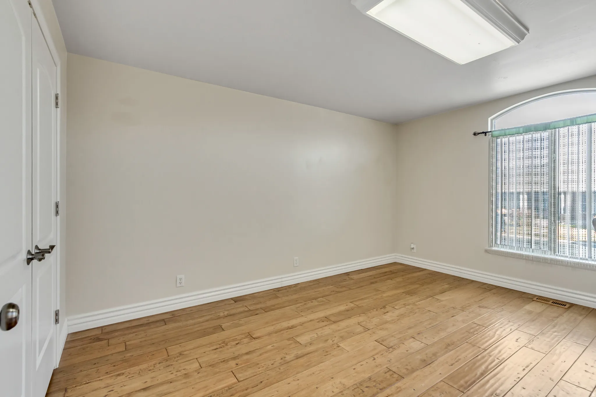 Unfurnished room with baseboards and light wood-style flooring