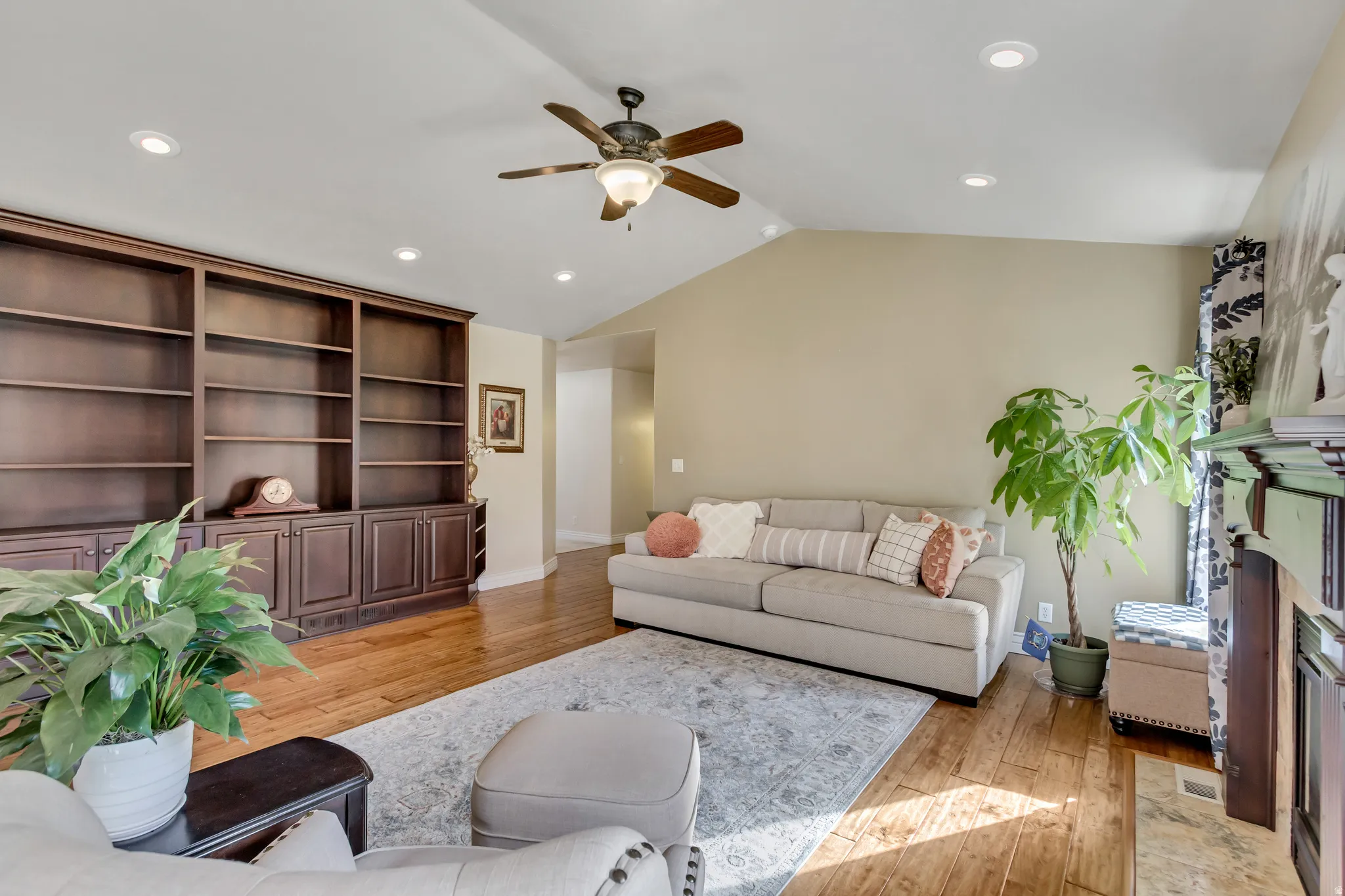 Living area with recessed lighting, light wood-type flooring, a premium fireplace, vaulted ceiling, and a ceiling fan