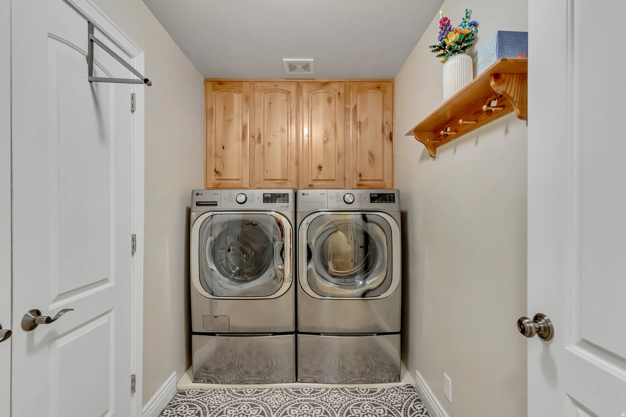 Laundry area with cabinet space and washing machine and clothes dryer
