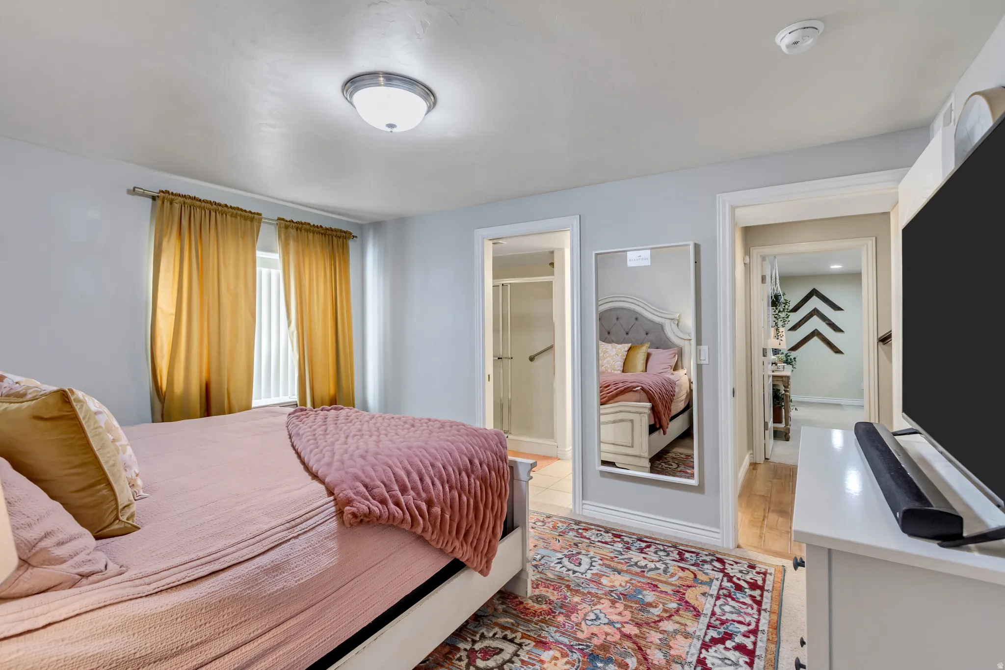 Bedroom featuring ensuite bathroom and baseboards