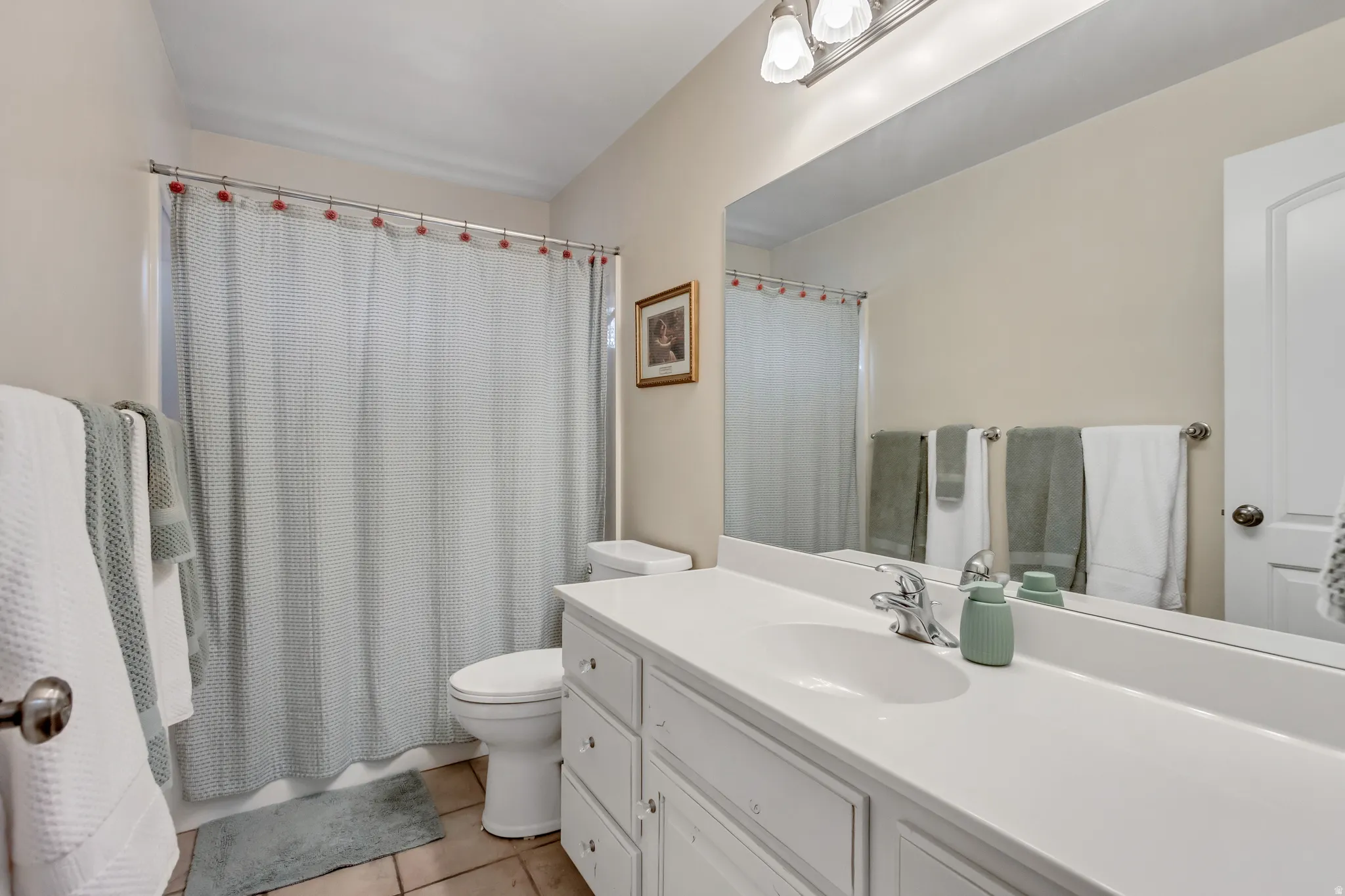Full bath featuring vanity and light tile patterned floors