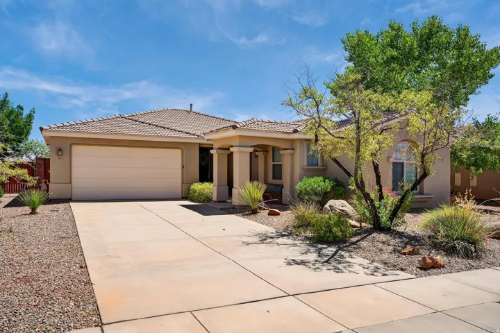 View of front of home featuring stucco siding, driveway, a garage, and a tile roof