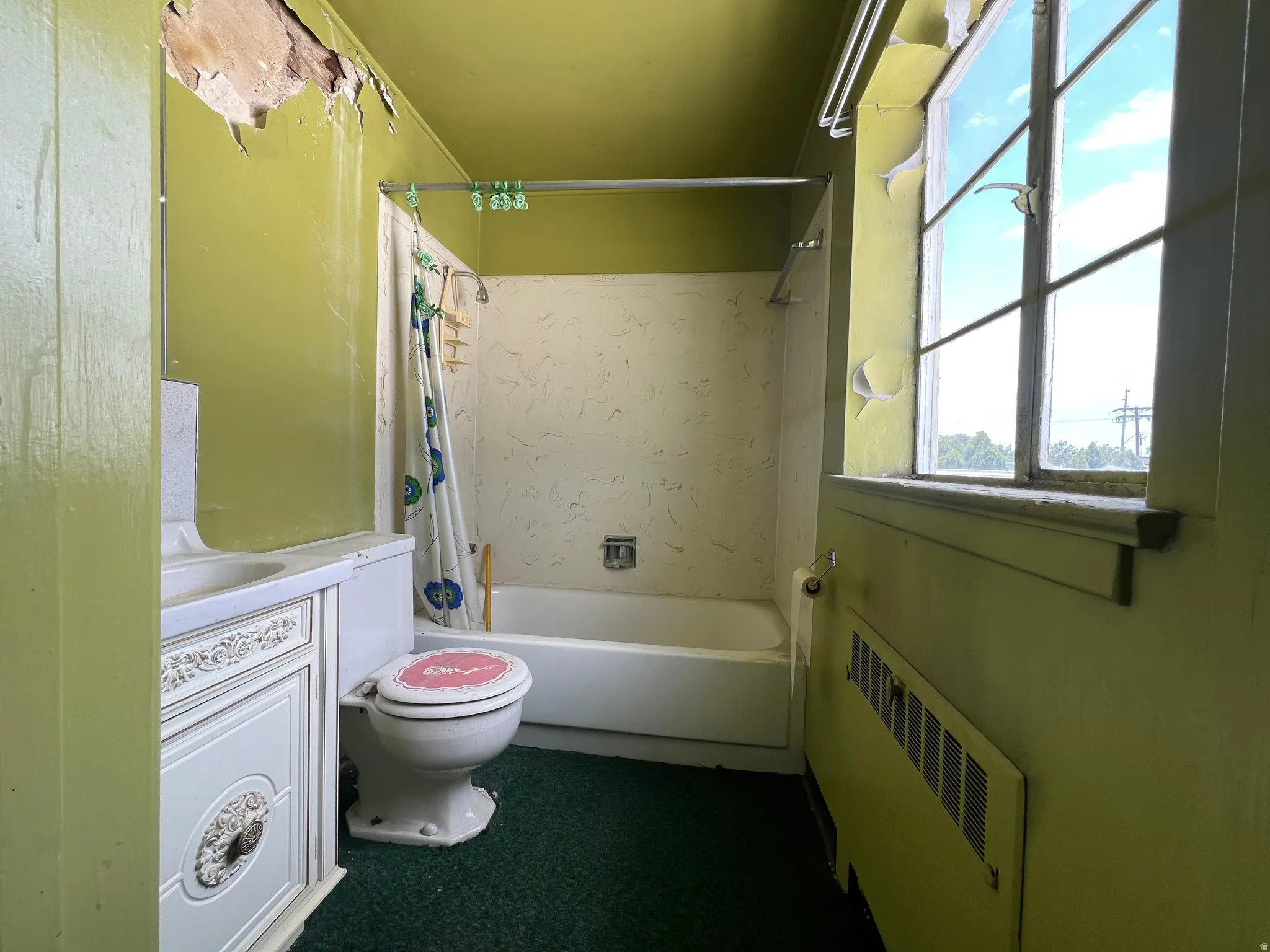Bathroom featuring radiator heating unit, shower / tub combo, and vanity