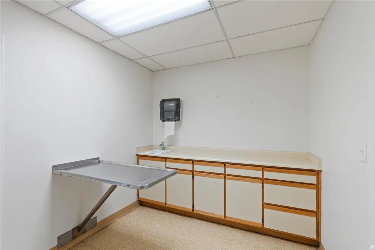 Miscellaneous room with a drop ceiling and a sink