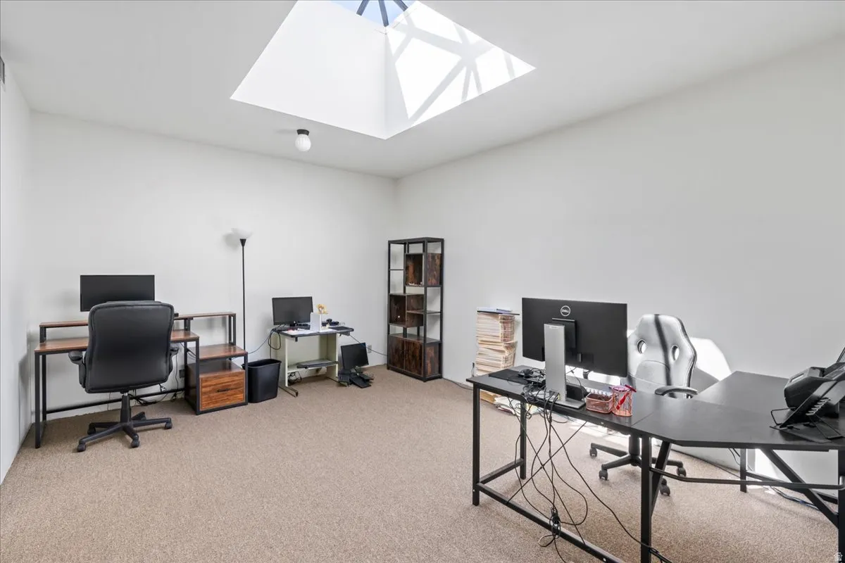 Office area featuring light carpet and a skylight
