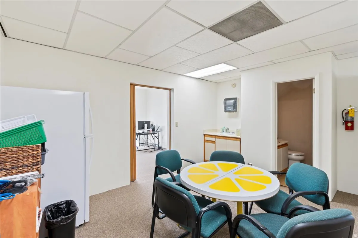Dining area with a drop ceiling and light colored carpet