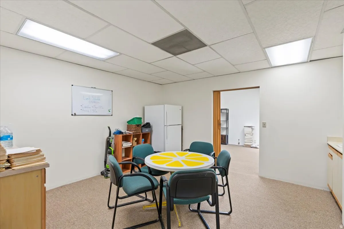 Dining room featuring a paneled ceiling and light carpet