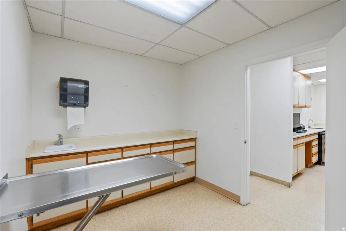 Misc room with a paneled ceiling and built in study area