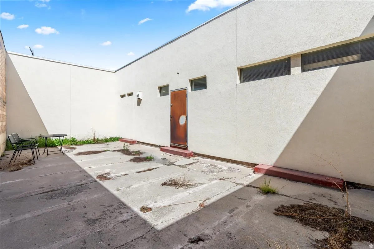 View of exterior entry featuring stucco siding and a patio