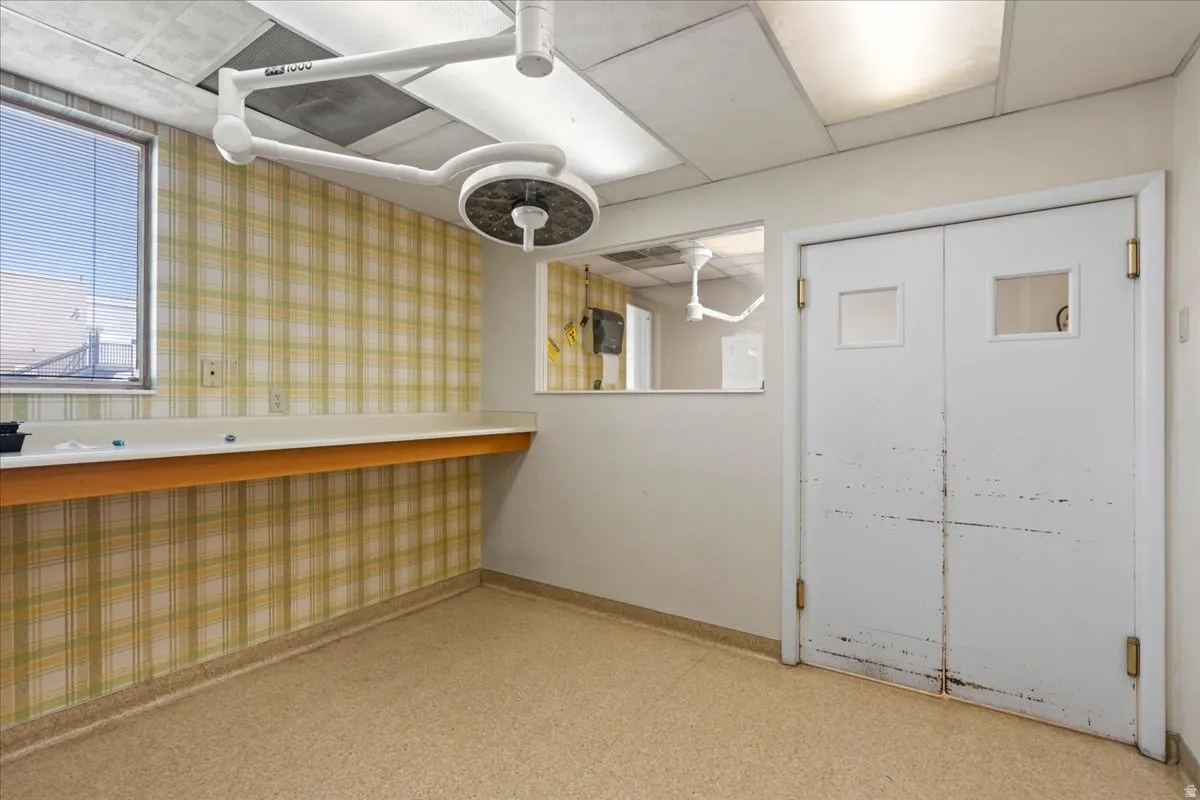 Below grade area with wallpapered walls and light flooring