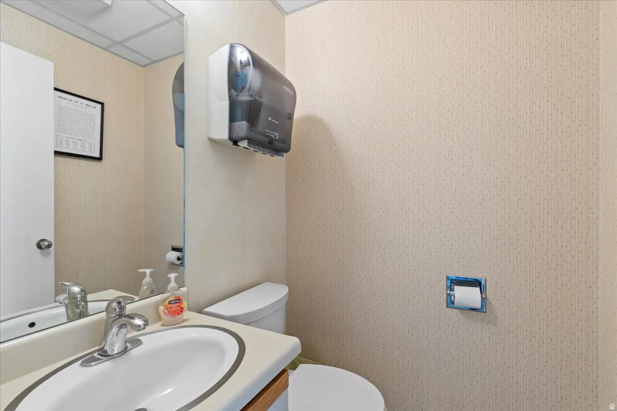 Bathroom with vanity and wallpapered walls