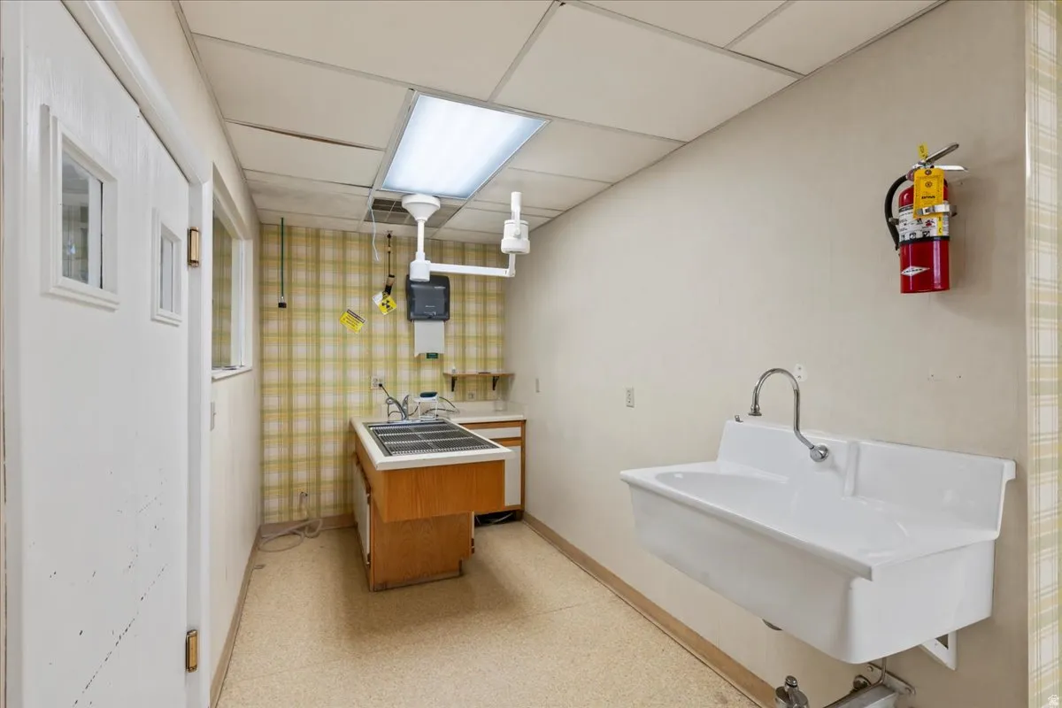 Bathroom featuring a paneled ceiling, vanity, and light floors
