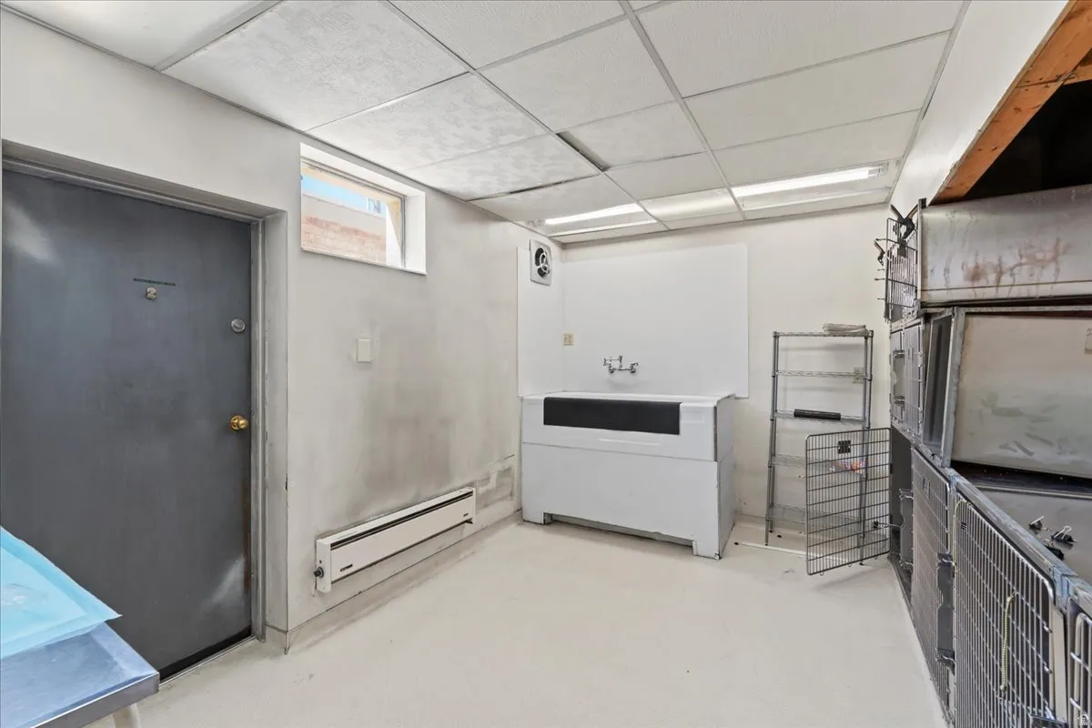 Kitchen featuring a paneled ceiling, baseboard heating, and finished concrete floors