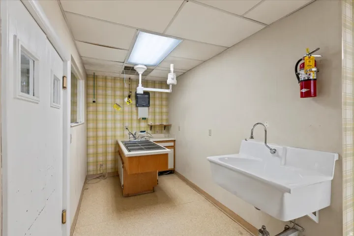 Bathroom featuring a paneled ceiling, vanity, and light floors