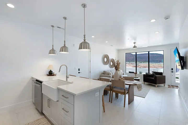 Kitchen with recessed lighting, decorative light fixtures, a peninsula, light stone countertops, and light tile patterned floors