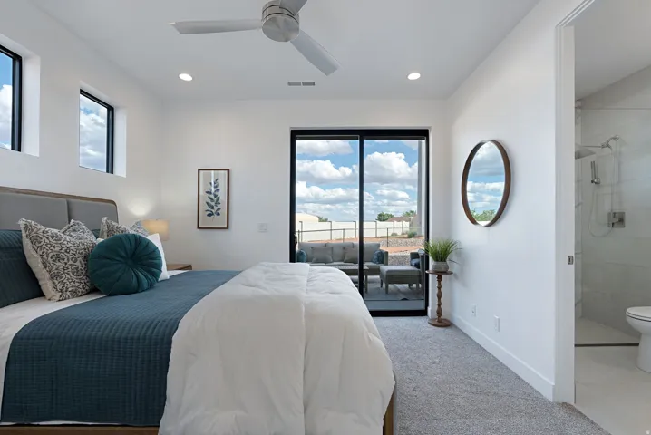 Bedroom featuring access to exterior, multiple windows, light carpet, ensuite bathroom, and recessed lighting