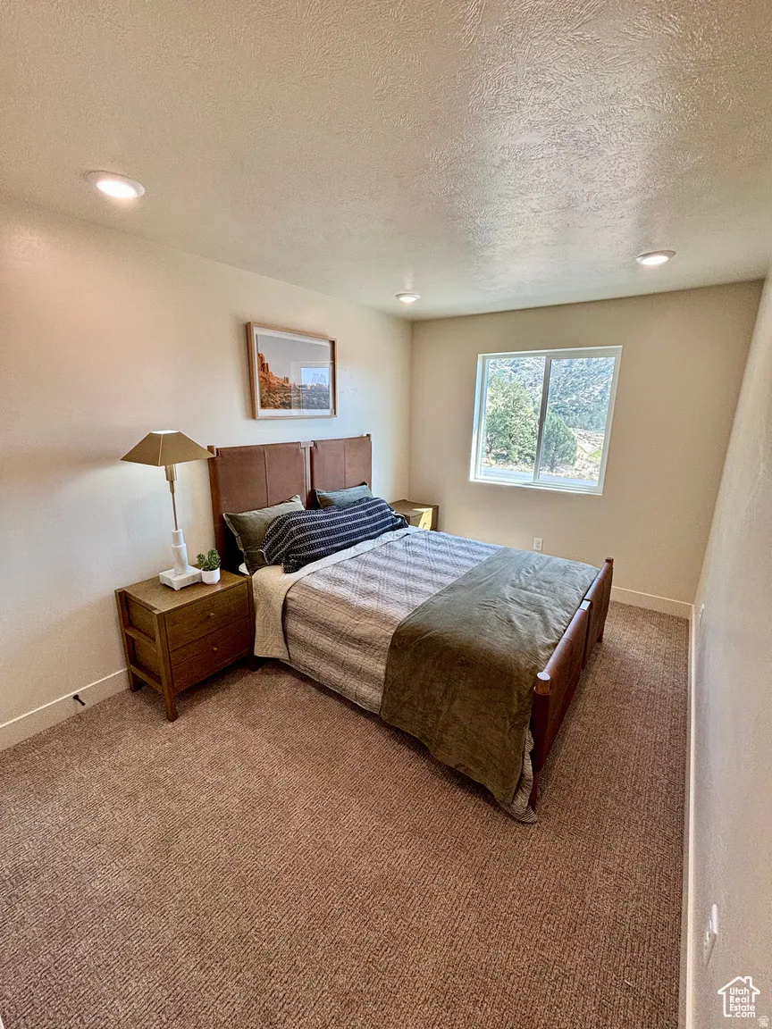 Bedroom with carpet, recessed lighting, and a textured ceiling