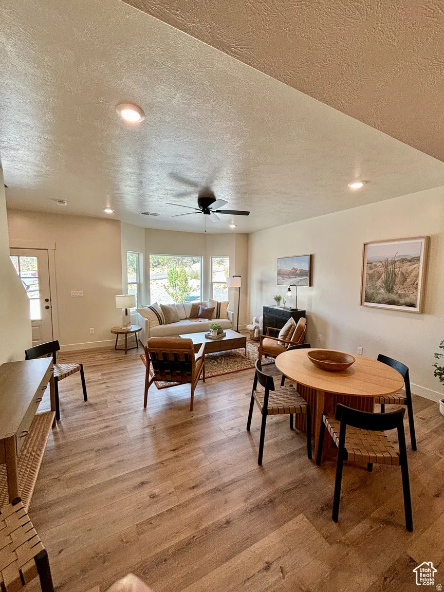 Dining area with recessed lighting, light wood-type flooring, a textured ceiling, and a ceiling fan