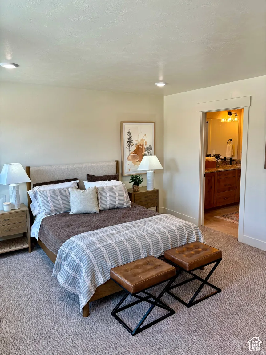 Bedroom with light colored carpet and ensuite bath