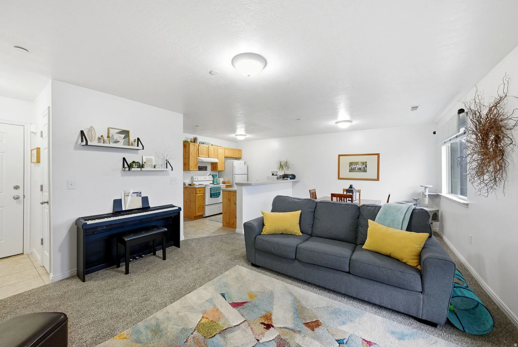 Living area featuring light colored carpet and light tile patterned flooring