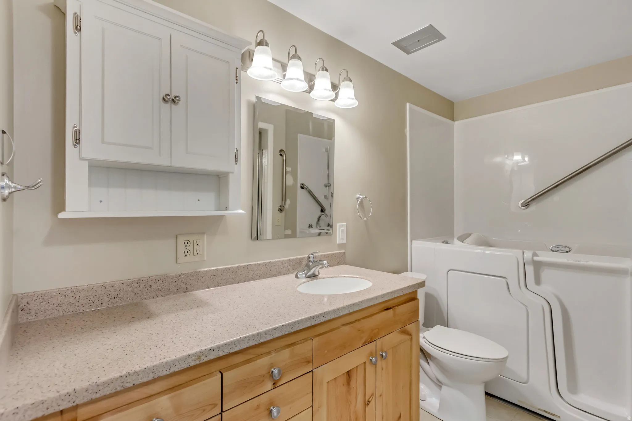 Bathroom featuring vanity, toilet, and wolk-in tub