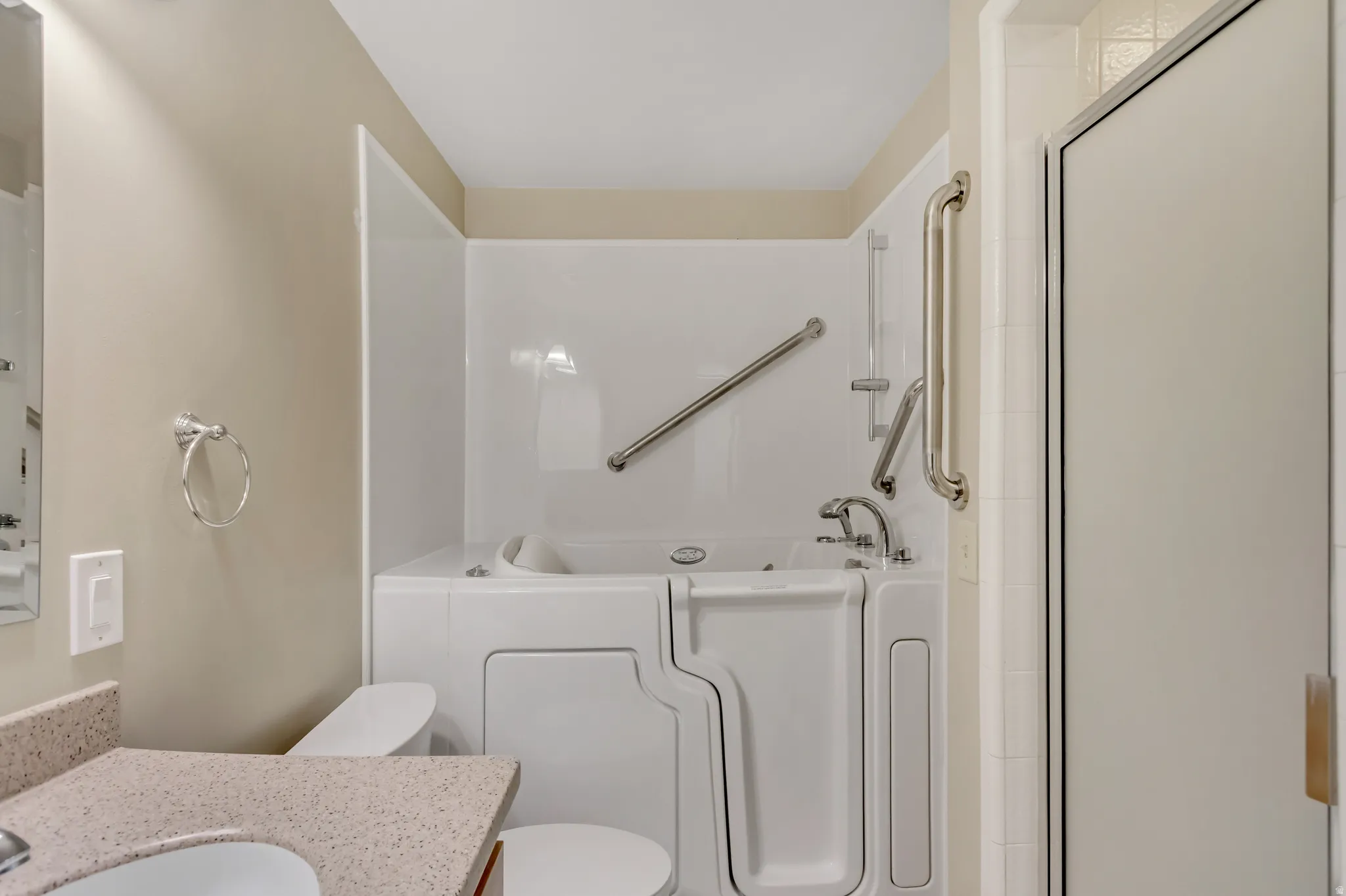 Bathroom featuring a bath, vanity, a shower with shower door, and walk-in tub