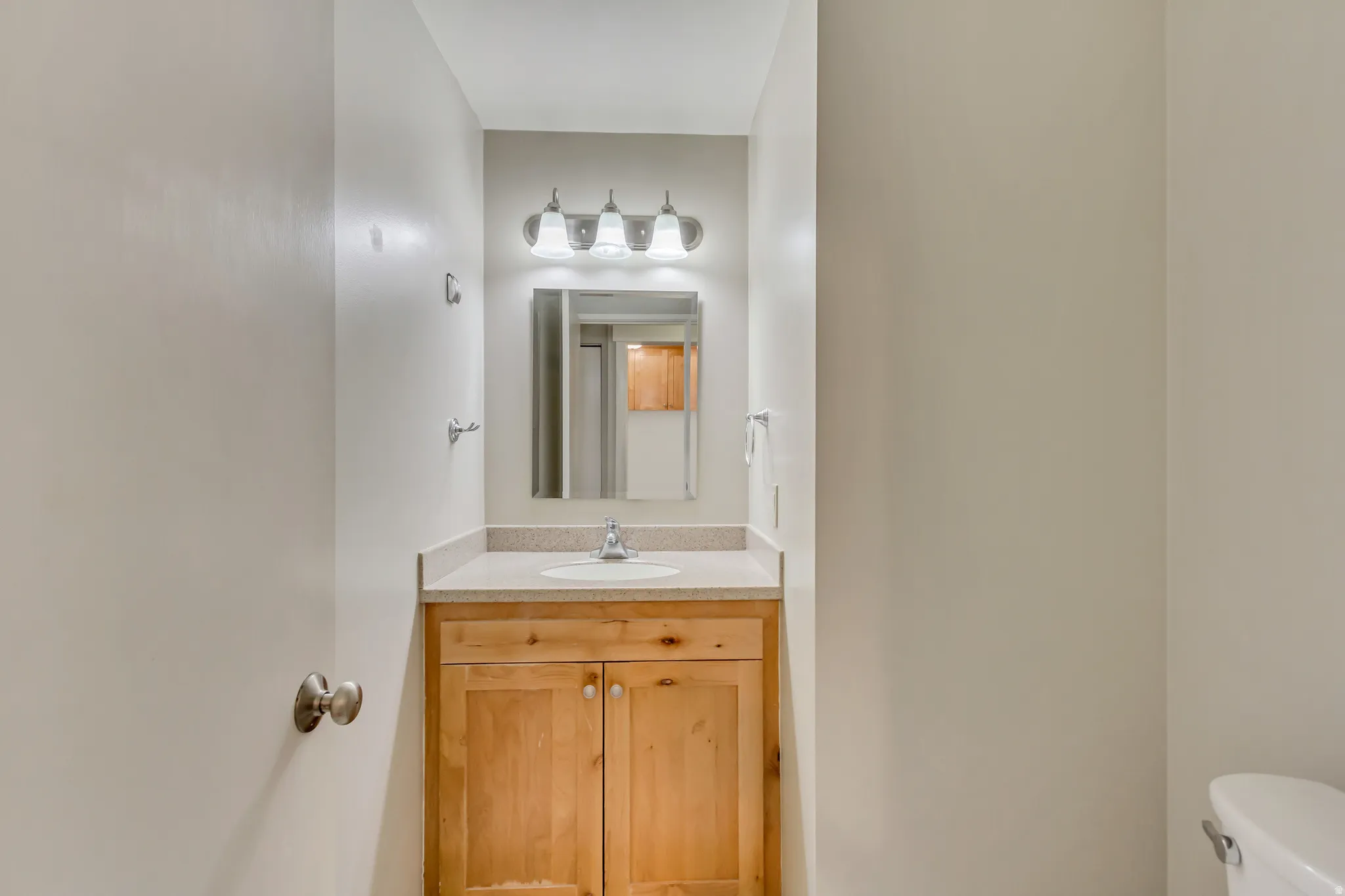 Half bathroom featuring vanity and toilet