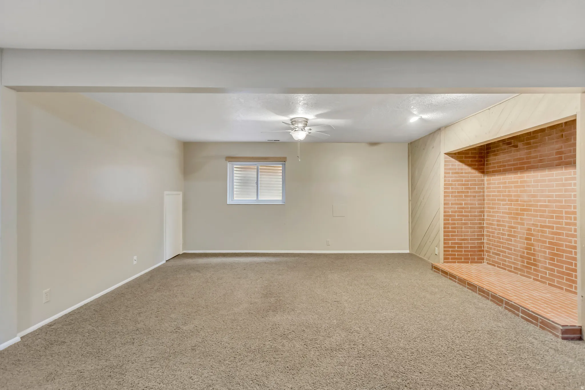 Basement featuring carpet floors, ceiling fan, and a textured ceiling