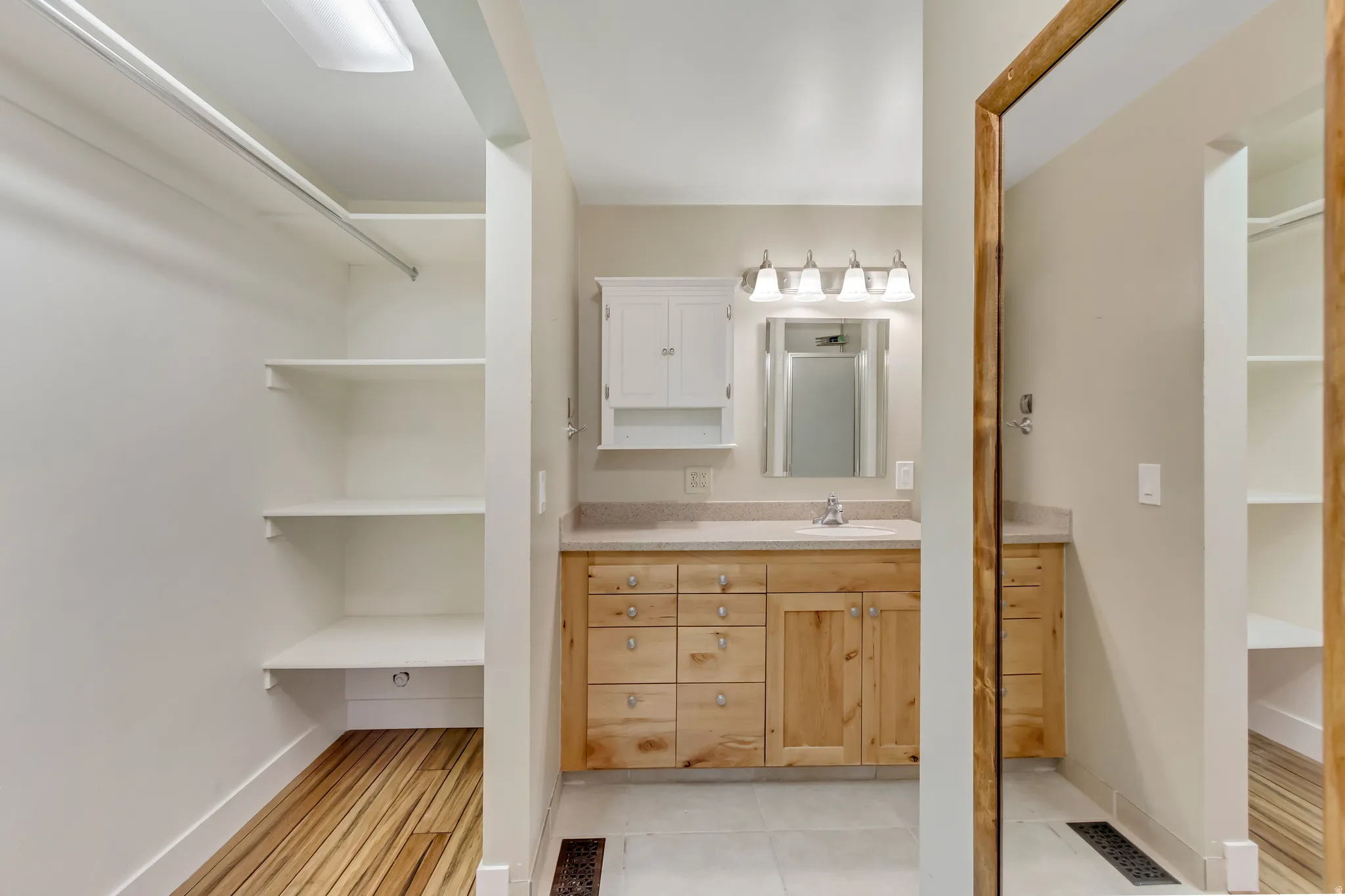 Full bathroom featuring vanity and a walk in closet