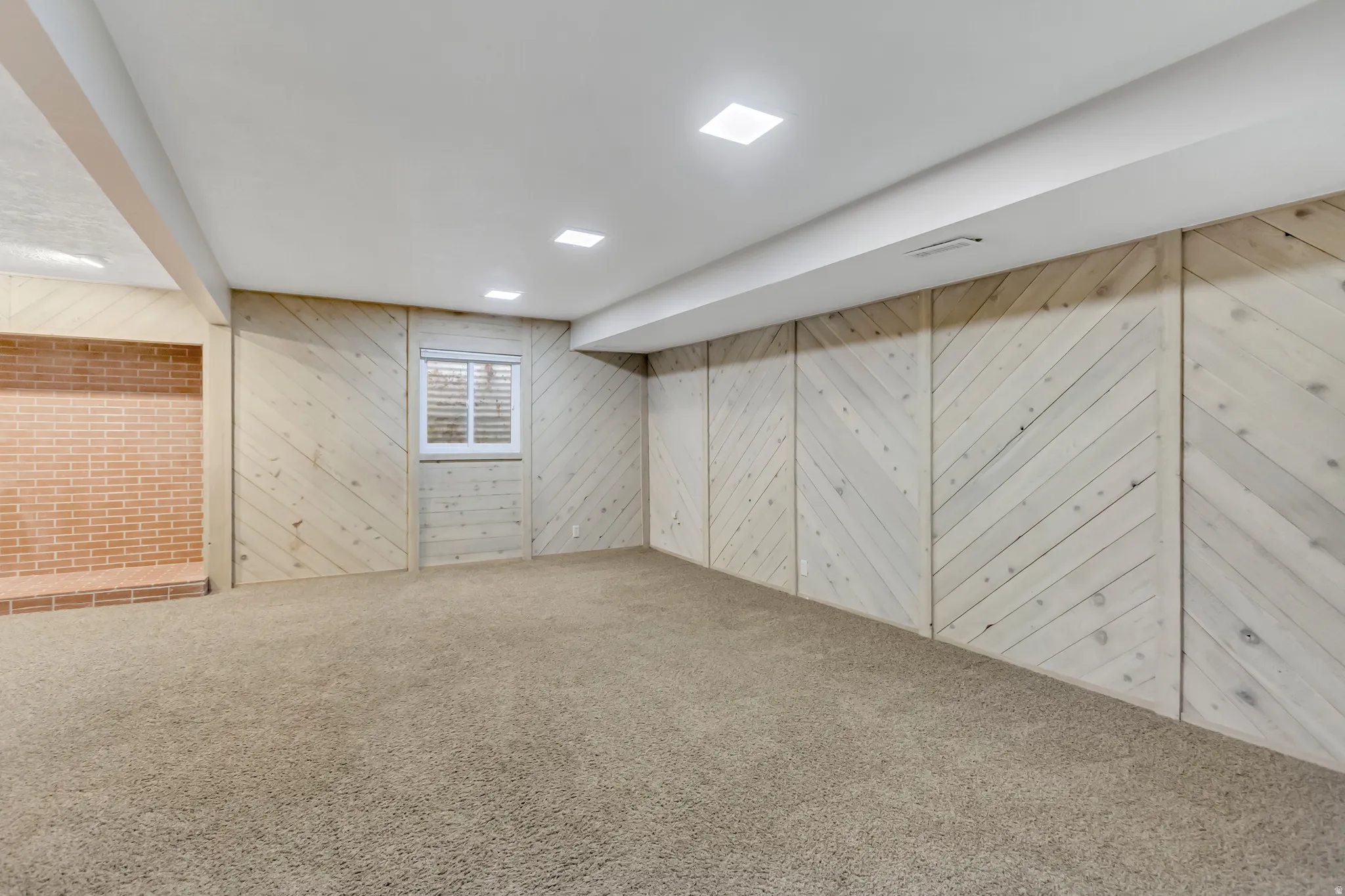 Finished basement with wood walls and carpet flooring
