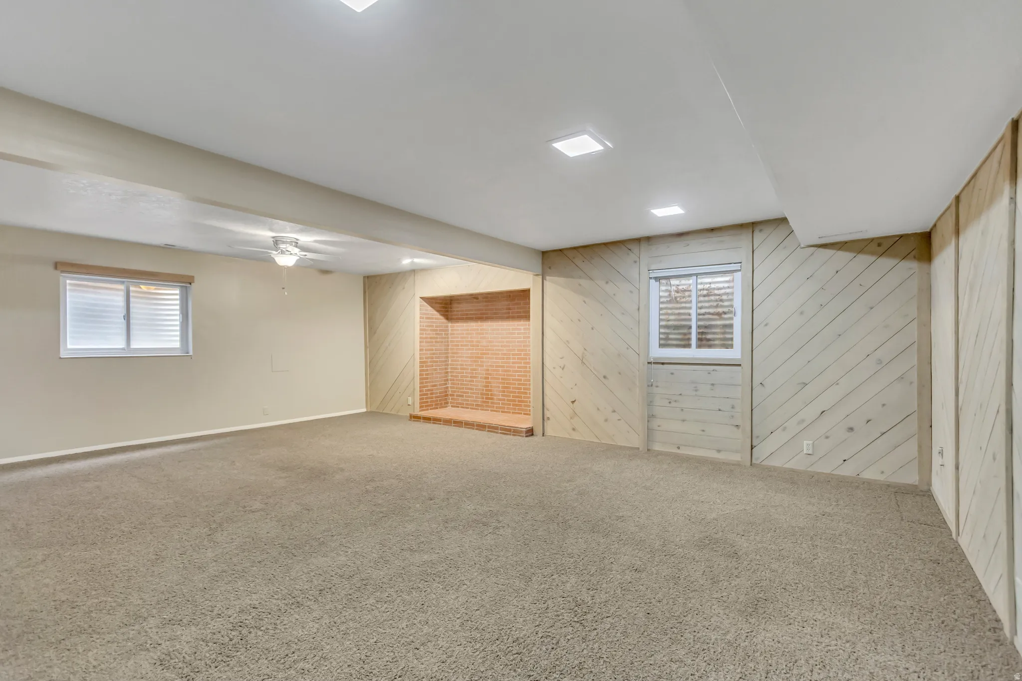 Basement featuring wood walls, carpet, and plenty of natural light