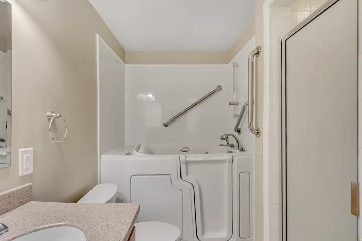 Bathroom featuring a bath, vanity, a shower with shower door, and walk-in tub