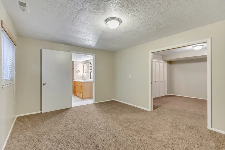 Unfurnished bedroom featuring a textured ceiling and light carpet