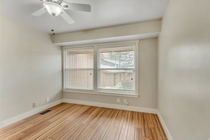 Bedroom 2 with light wood finished floors and a ceiling fan