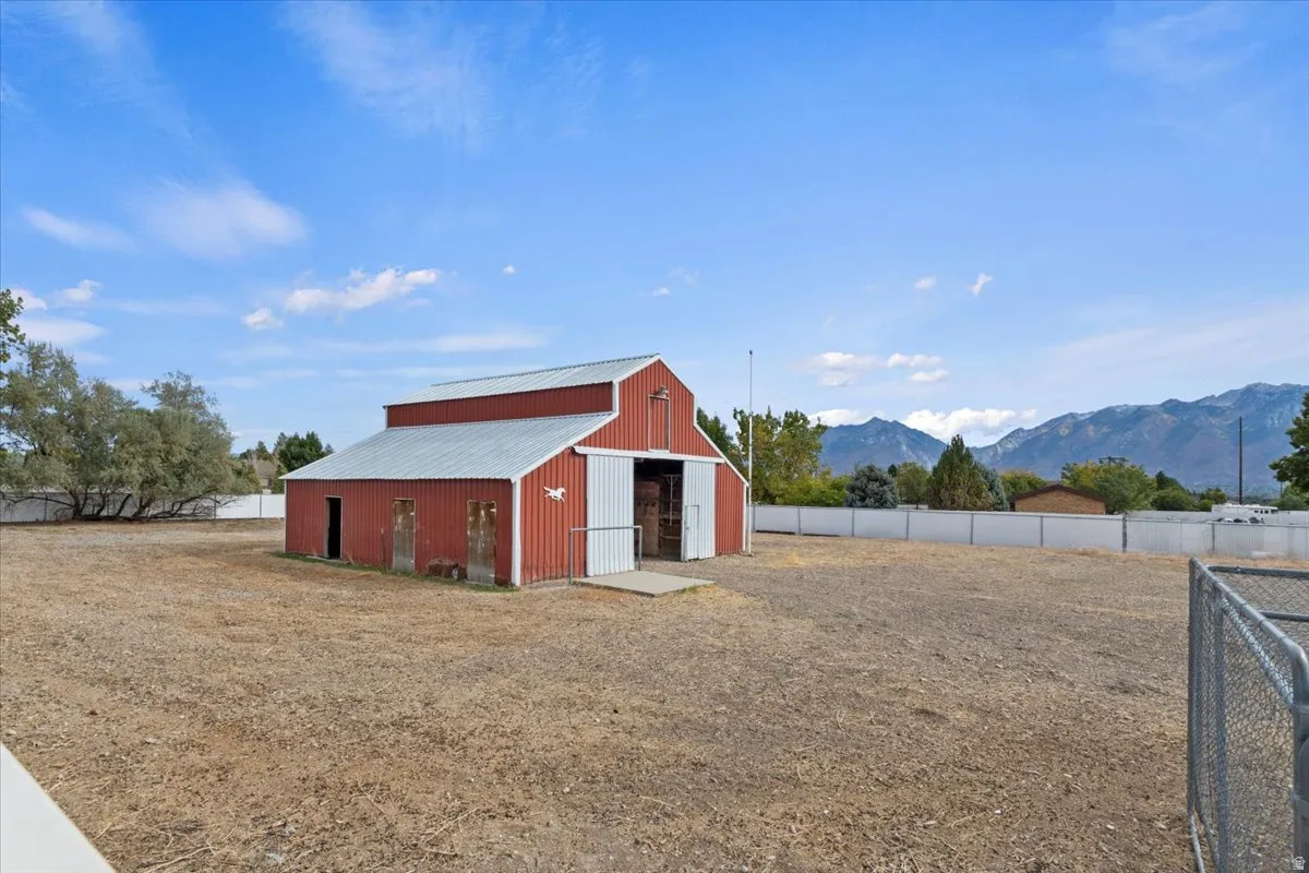View of yard featuring a pole building, an outdoor structure, and a mountain view