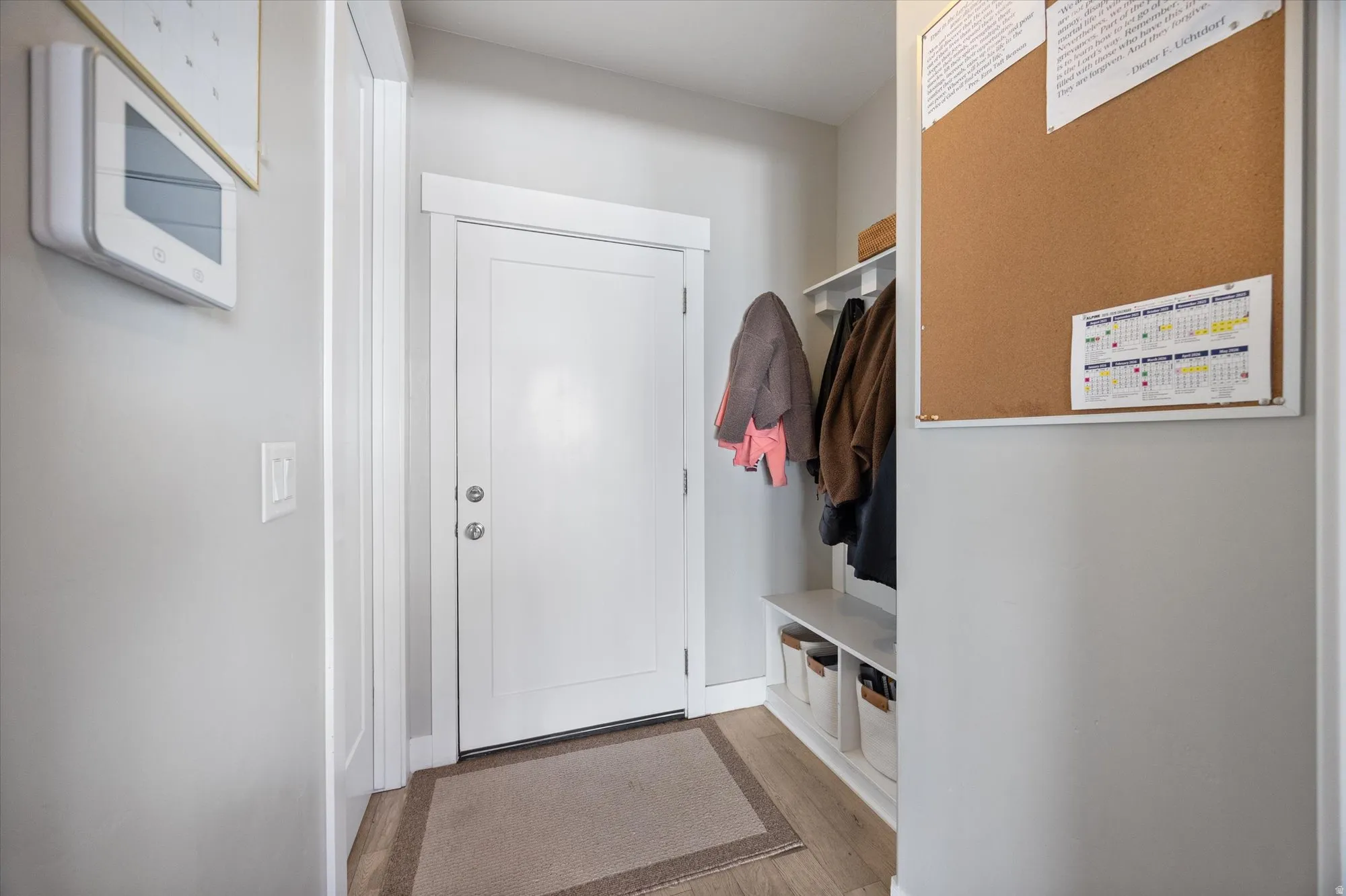 Mudroom area with bench and coat hangers.  Access to the half bathroom and garage.