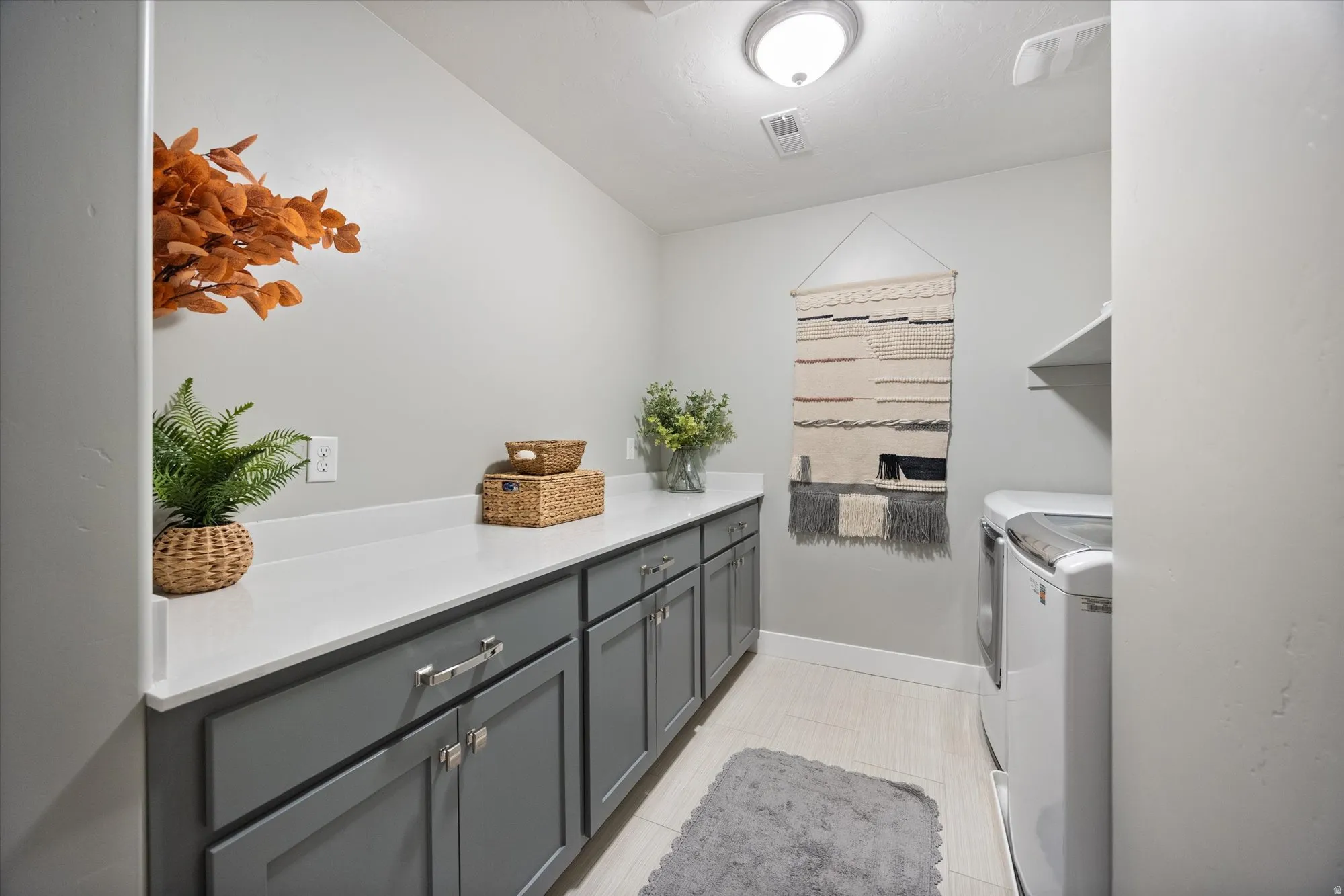 Spacious laundry room with build in cabinetry, extra long countertop and lots of storage
