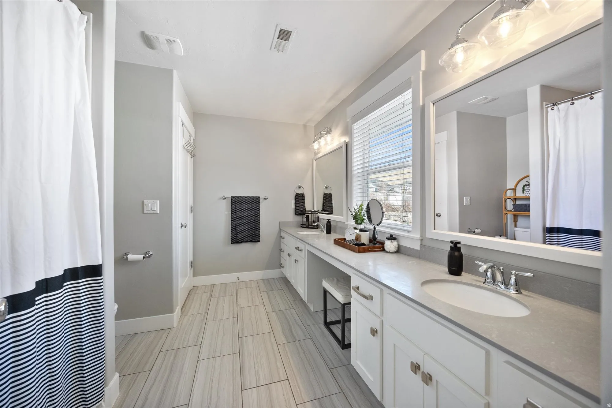 Jack-andJill bathroom with extra long countertop and dual sinks, shower and toilet