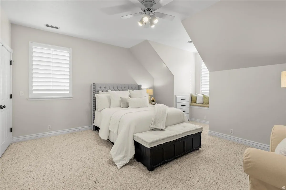 Bedroom featuring light carpet, a ceiling fan, and lofted ceiling