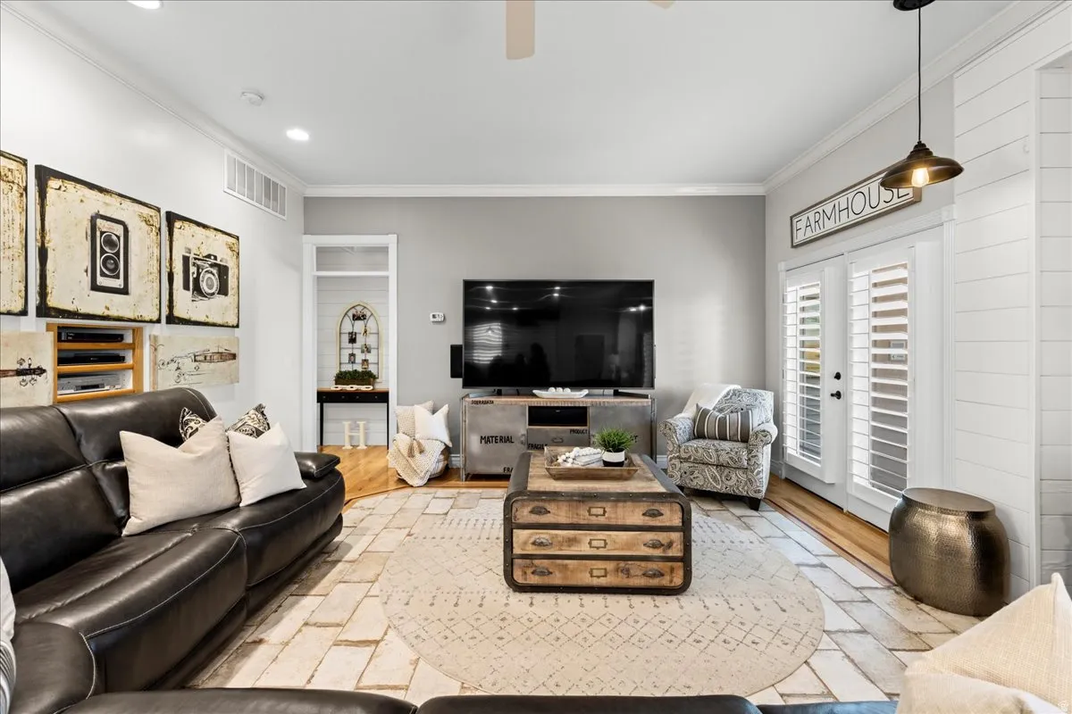 Living area with crown molding, wood finished floors, and a ceiling fan
