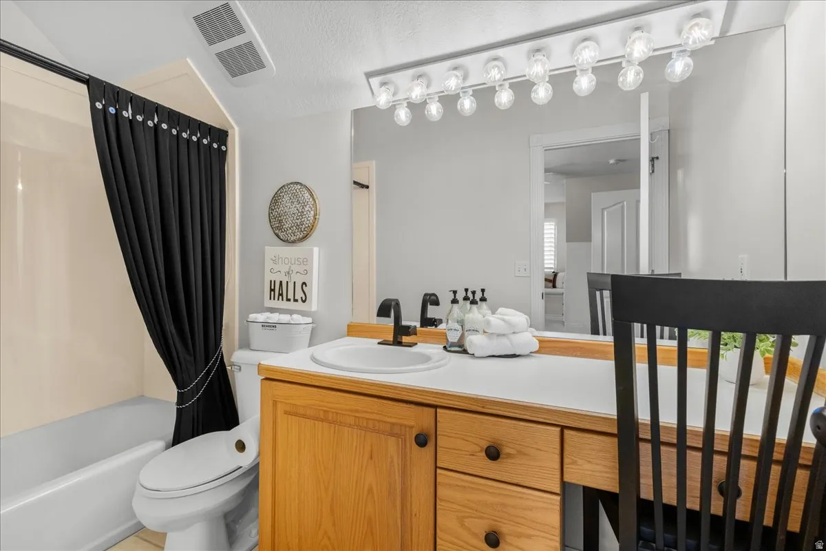 Bathroom with vanity and shower / bath combination with curtain