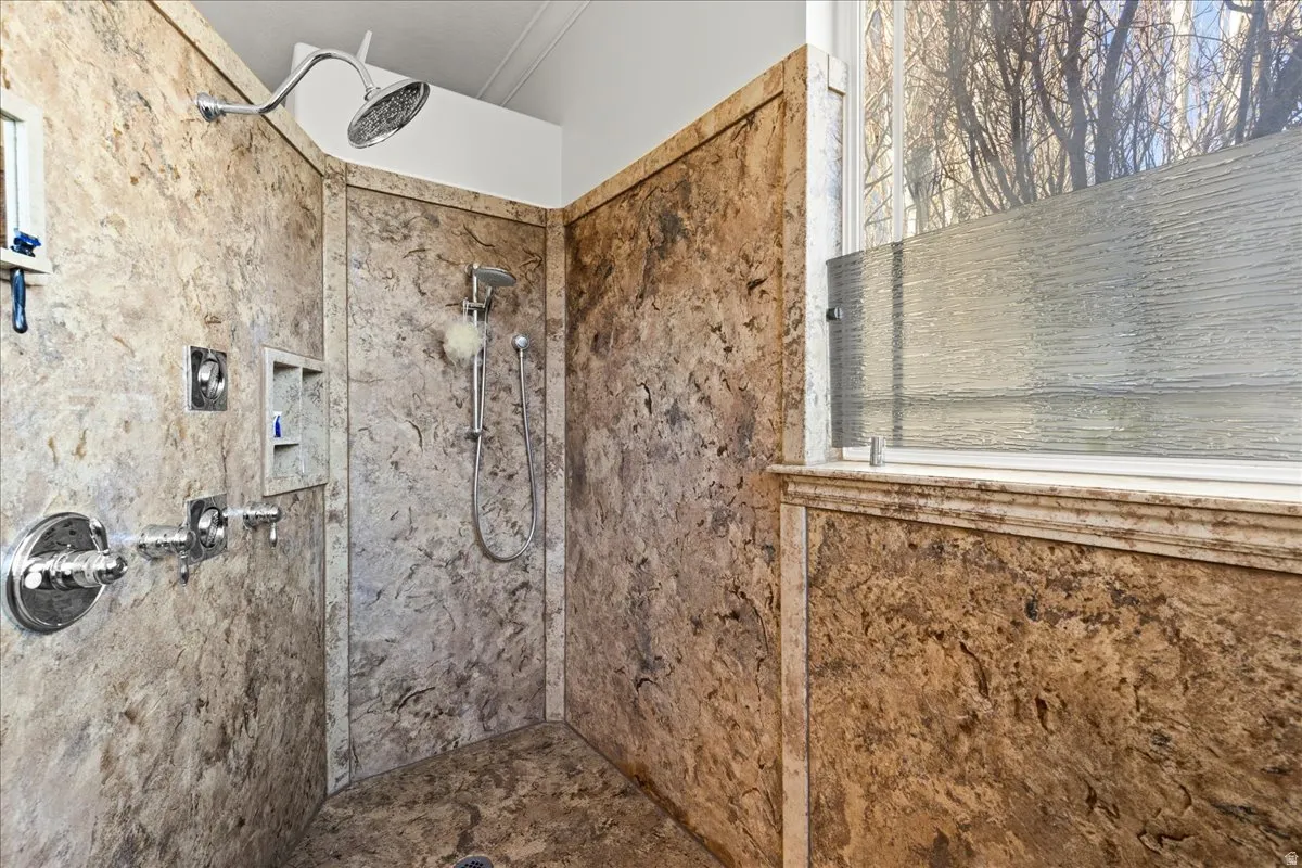 Full bath with tiled shower and ornamental molding