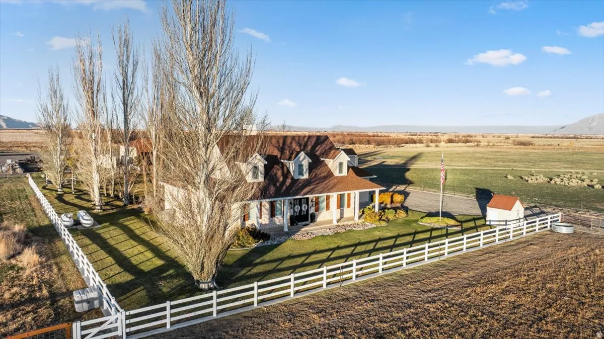 Exterior space featuring a view of rural / pastoral area, a fenced front yard, a mountain view, and covered porch
