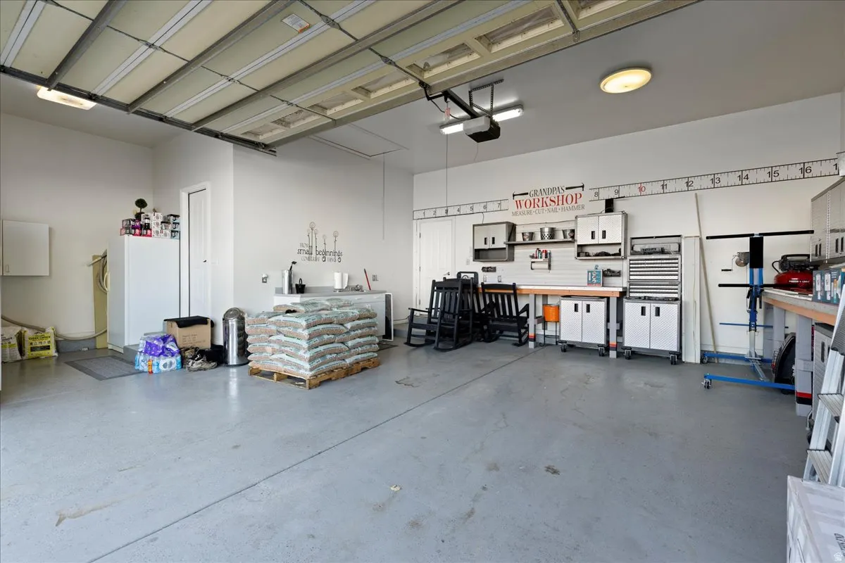 Garage featuring a workshop area and freestanding refrigerator